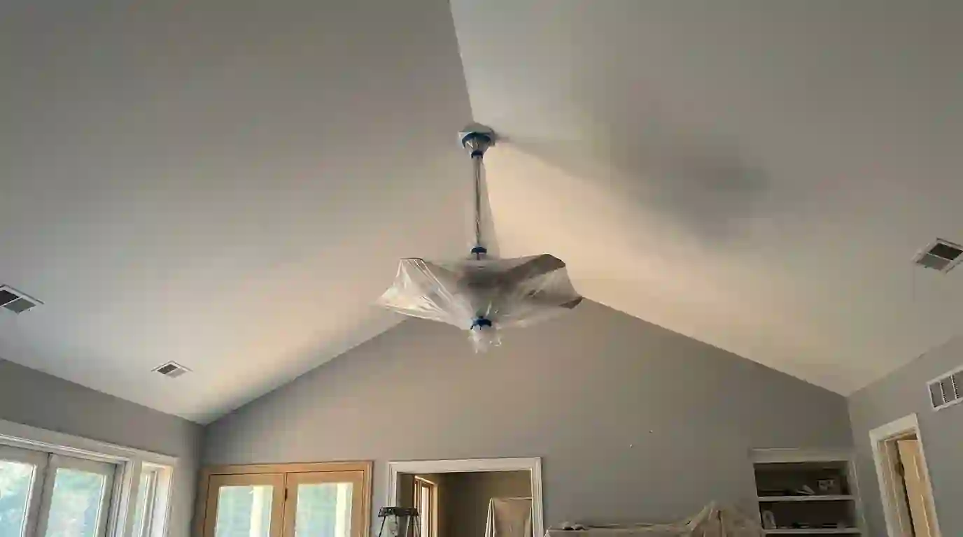 Vaulted family room ceiling freshly painted with the fan wrapped