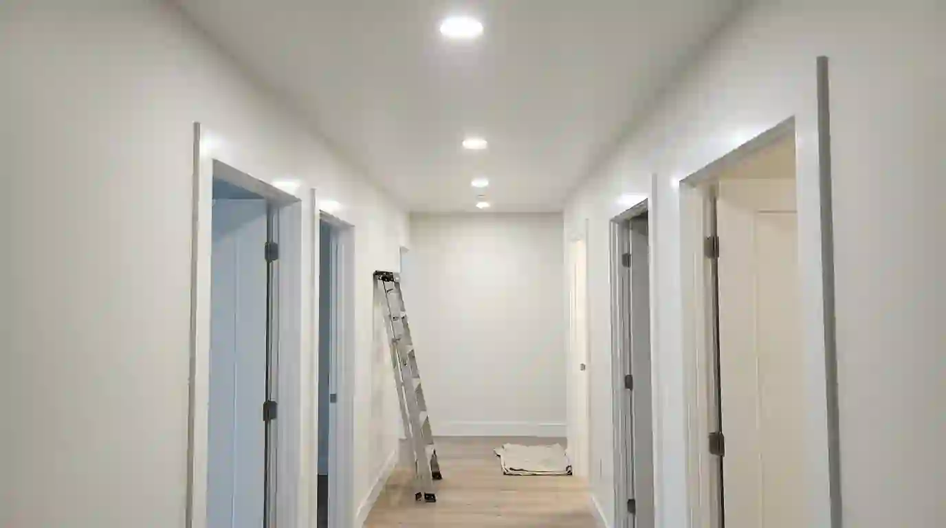 Repainted ceiling and door casing in an empty condo hallway