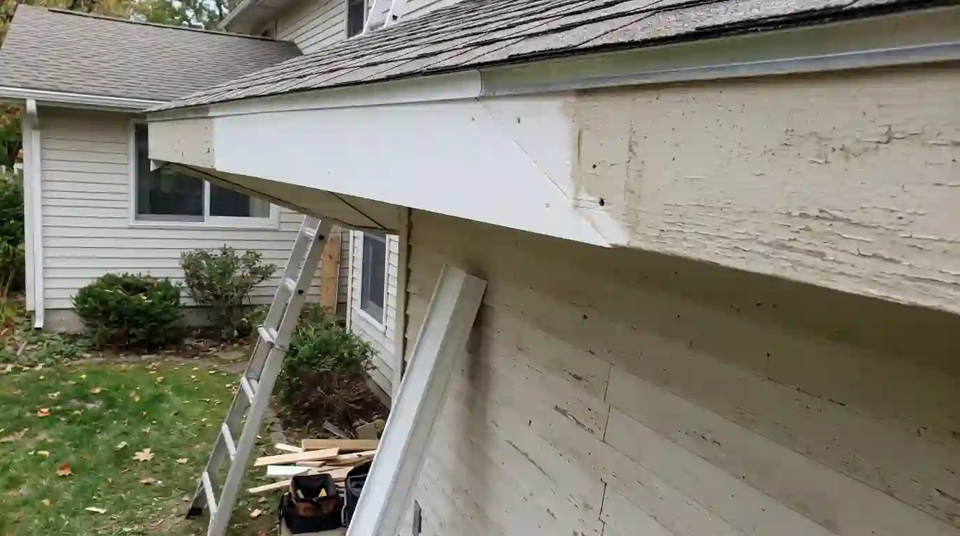 New primed fascia board spliced into an old roofline