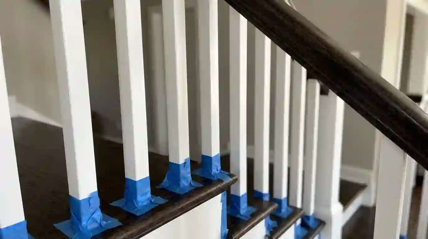 Freshly painted white balusters below a dark handrail